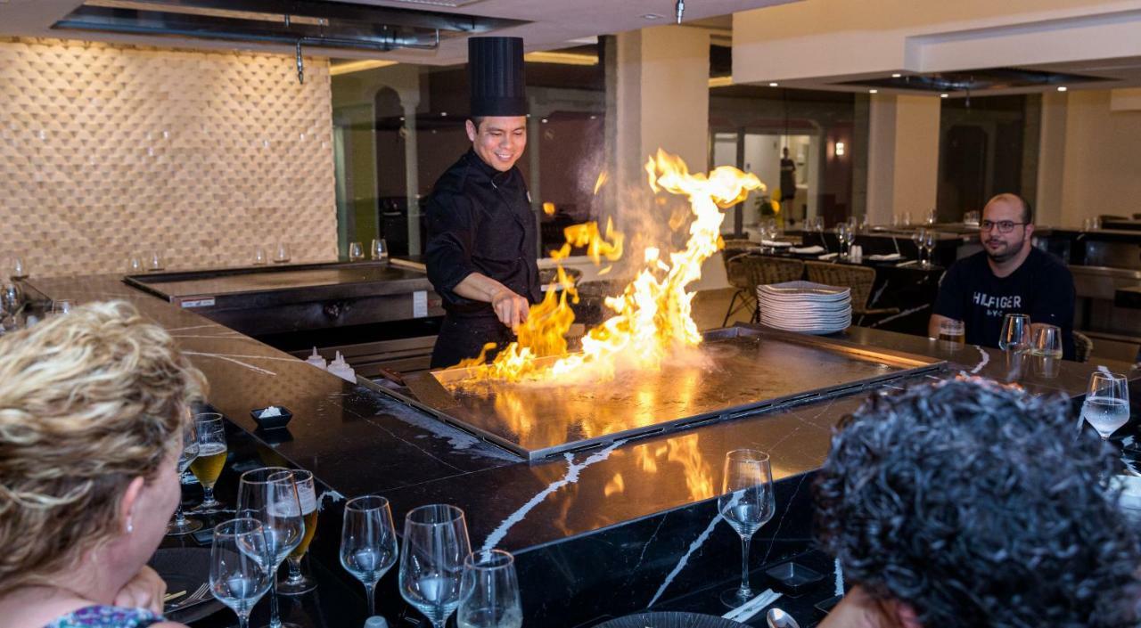 فندق Senator بويرتو بلاتا المظهر الخارجي الصورة A chef cooking with a flaming grill